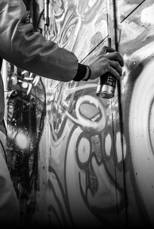 man spray painting wall